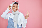 Woman, scarf and flower with peace sign and smile for beautiful casual fashion against pink studio background. Portrait of happy muslim female smiling in happiness and showing hand gesture on mockup