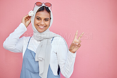 Buy stock photo Woman, scarf and flower with peace sign and smile for beautiful casual fashion against pink studio background. Portrait of happy muslim female smiling in happiness and showing hand gesture on mockup