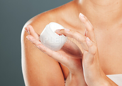 Buy stock photo Hand, cream and skincare beauty of a woman with moisturizer product in hands in studio. Isolated, gray background and person with cosmetic, dermatology and spa lotion for skin and female body glow