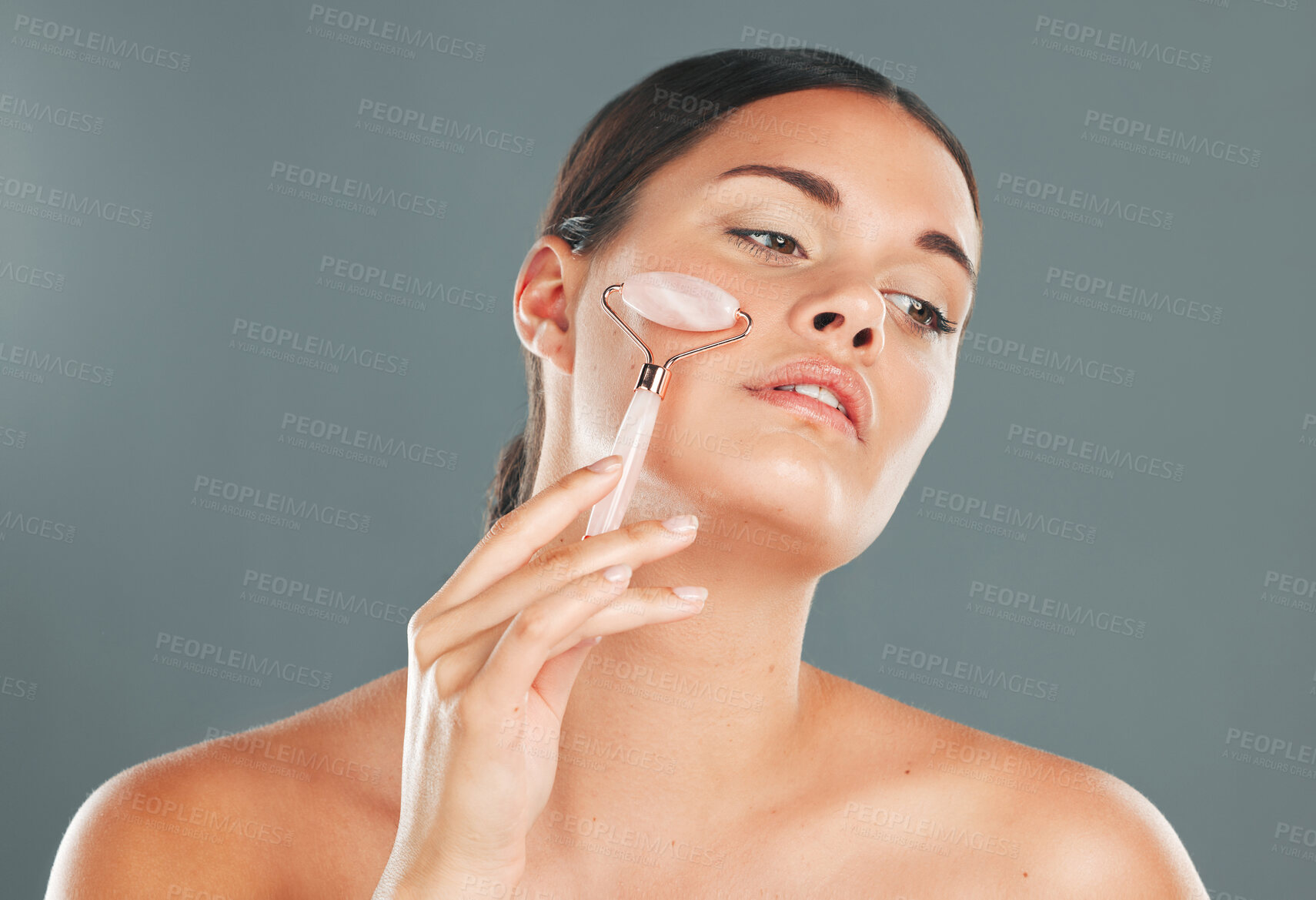 Buy stock photo Face massage with roller, woman and skincare with beauty tools and healthy skin isolated on studio background. Natural cosmetics, glow and makeup with hand, manicure and wellness for cosmetic care