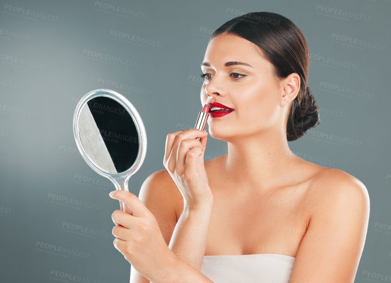 Buy stock photo Lipstick, woman and mirror on studio background for beauty, fashion and aesthetics. Young model, red lips and makeup application with reflection for glamour cosmetics, elegant skincare or cosmetology