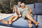 Senior couple, relax and smile for video call, social media or selfie together on outdoor patio at home. Happy elderly man and woman relaxing on comfortable cushion for online chat or communication