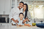 Kitchen, family and portrait of mother, father and young child together cooking with happiness. Happy, smile and parent love of children in a house making food for dinner ready for eating at home