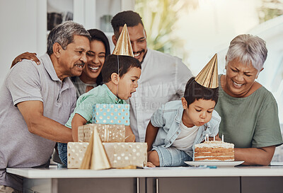 Buy stock photo Birthday, celebration and twin children with family blowing the candles on a cake at their party. Happy, excited and kids with their parents and grandparents in the kitchen of their home to celebrate