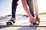 Sand, board and man tie shoes ready for desert surfing, extreme sports and action hobby in nature. Freedom, adventure and feet of athlete outdoors for fitness, exercise and dune surfer training