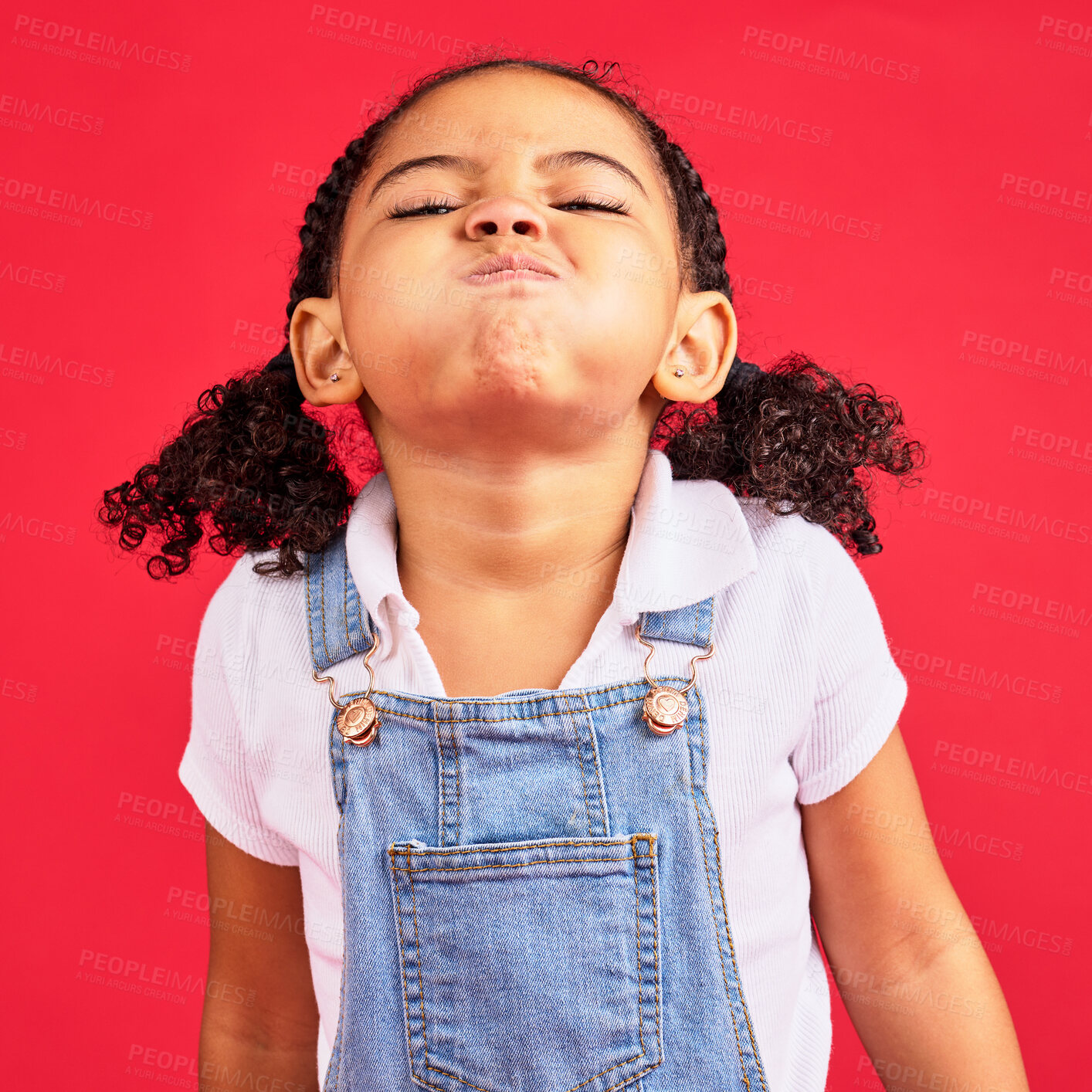 Buy stock photo Attitude, childhood and face of girl on red background in studio with angry, upset and frustrated reaction. Emoji, comic and young kid with air in cheeks, tantrum behaviour and mad facial expression