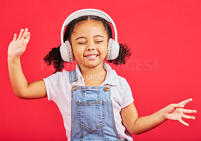 Buy stock photo Dancing, energy and child on music headphones, fun radio or loud podcast on isolated red background or studio backdrop. Smile, happy kid and girl listening to dance audio, sound and streaming media