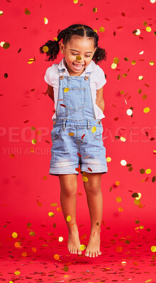 Buy stock photo Young girl, kid jump with confetti, happiness and party with celebration, gold and glitter isolated against red background. Fun, youth and happy child at event, celebrate and birthday in studio 