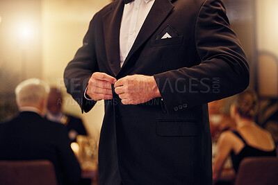 Buy stock photo Suit, formal and man tie the button of his jacket at a fancy dinner, party or event banquet. Classy, elegance and male fixing blazer of his elegant outfit at classic supper, celebration or gathering.