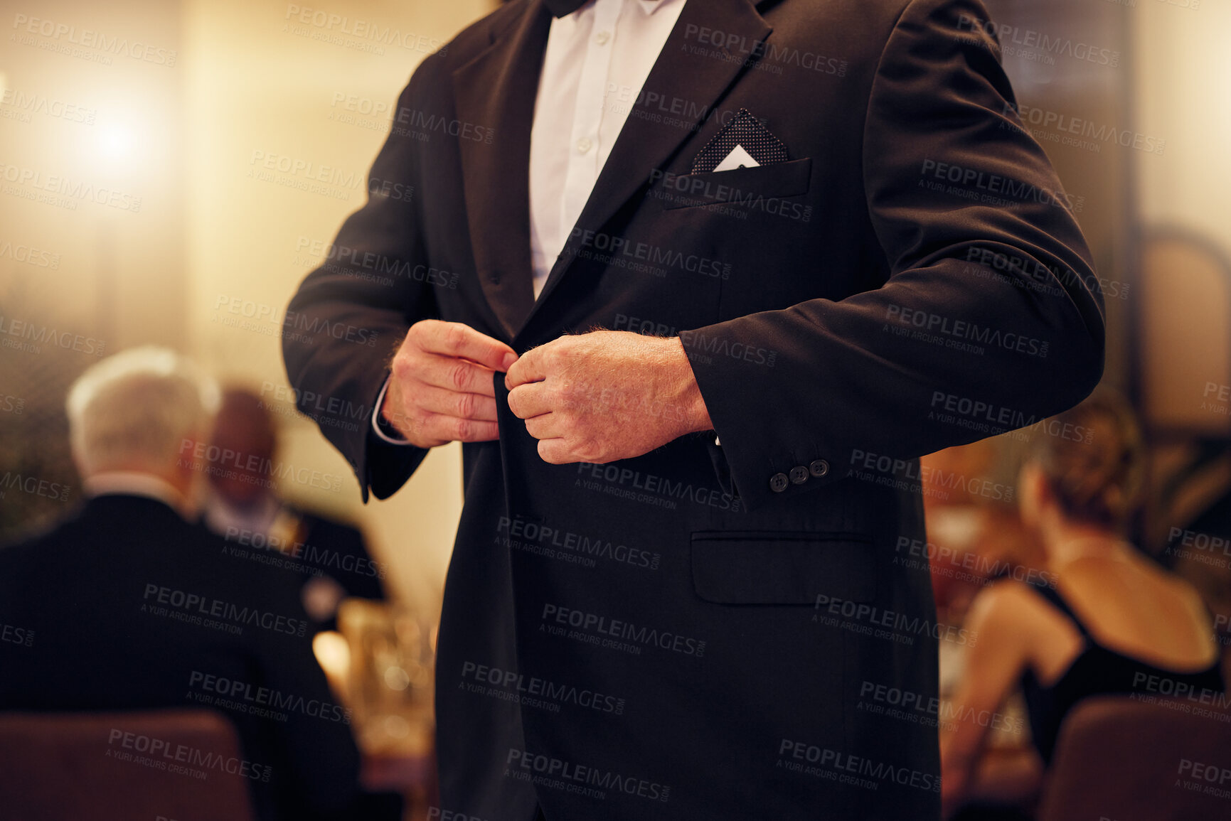 Buy stock photo Suit, formal and man tie the button of his jacket at a fancy dinner, party or event banquet. Classy, elegance and male fixing blazer of his elegant outfit at classic supper, celebration or gathering.