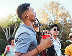 Drinks, party and a couple of friends outdoor to celebrate at  festival, concert or summer social event. Diversity young men and women crowd while happy, hug and drinking alcohol while listening