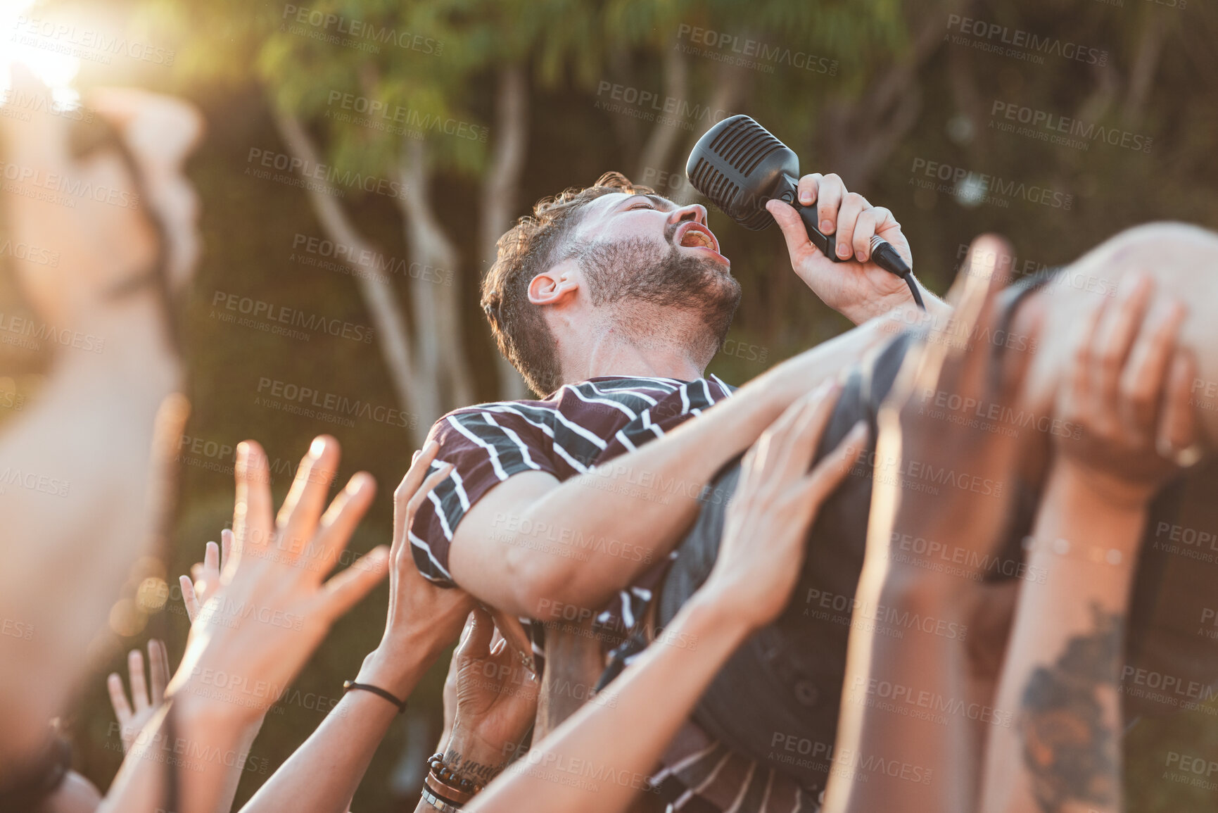 Buy stock photo Crowd, surfing and man singing at party, outdoor music festival or social gathering. Microphone, energy and male singer diving in audience group at performance event, celebration or crazy fun weekend