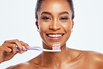 Portrait, cleaning and a black woman brushing teeth in studio isolated on a white background for oral hygiene. Face, toothbrush or toothpaste with a young female posing for dental care on blank space