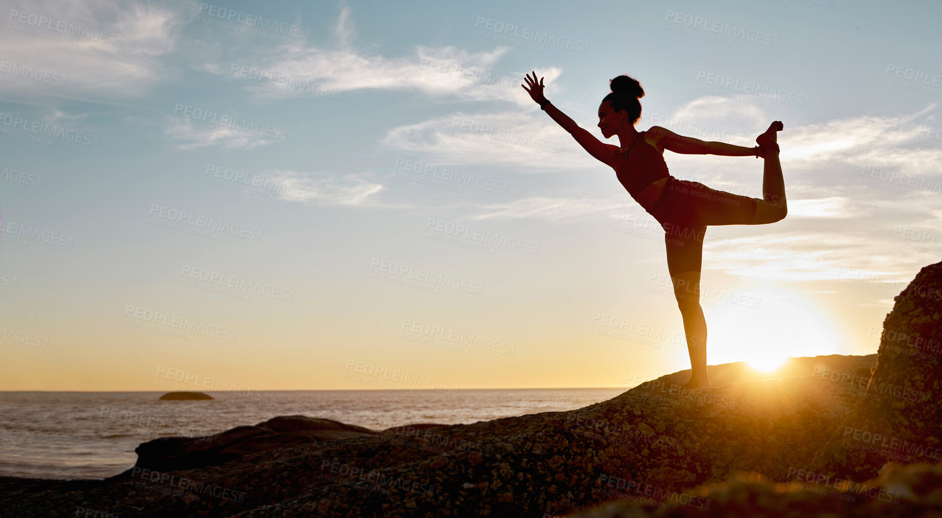 Buy stock photo Fitness, woman and yoga stretching in the sunset for spiritual wellness on a rock by the beach in the outdoors. Active female in calm, zen or warm up stretch for healthy exercise, training or workout