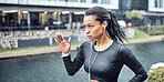 Black woman, fitness and running with earphones in the rain for sports motivation or determination in the city. African American sporty female runner doing intense cardio workout in the rainy weather