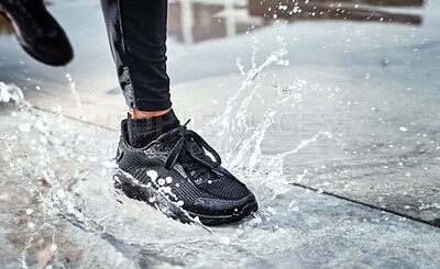 Buy stock photo Feet splash water in street, person running in the rain and shoes in puddle of Seattle road for outdoor cardio. Runner training for marathon, step on wet ground and moving fast for fitness exercise