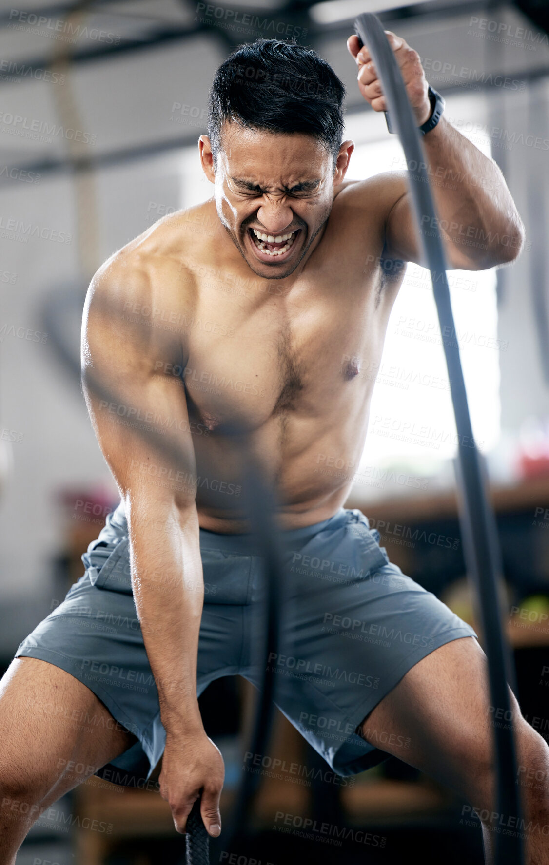 Buy stock photo Fitness, battle ropes or strong man training for body goals in painful workout or exercise at a sports gym. Resilience, mindset or healthy athlete with biceps power, motivation or focus exercising