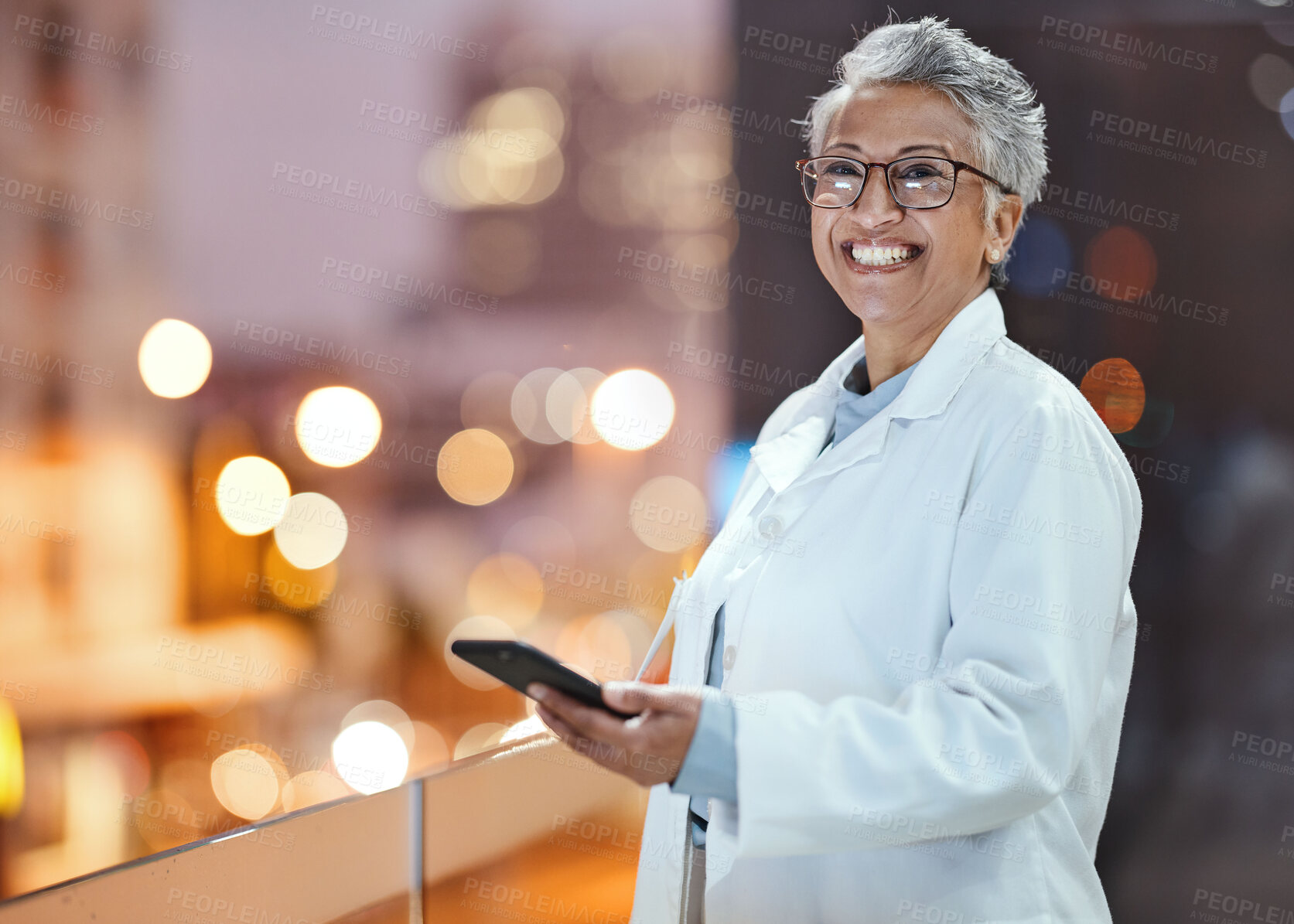 Buy stock photo Phone, doctor and senior woman on hospital rooftop for telehealth, research or online consultation in city. Bokeh, healthcare portrait and female physician with smartphone for wellness app at night.