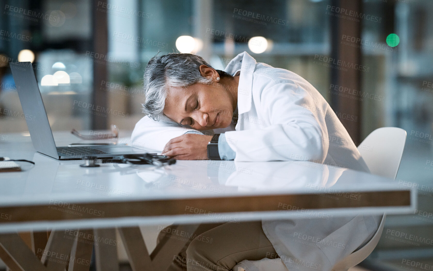 Buy stock photo Woman doctor sleeping at desk in overtime medical office, late hospital and burnout. Stress, night and healthcare worker nap at table with fatigue, tired job and mental health problem from overworked