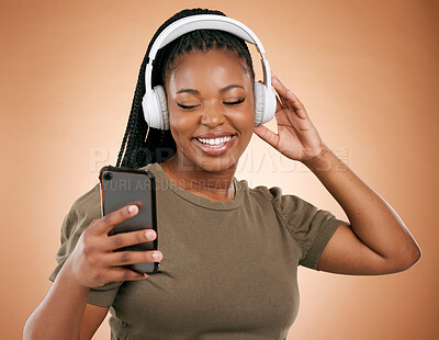 Buy stock photo Headphones, smartphone and black woman isolated on studio background for music streaming, dance and happy. Smile of african person, hand holding phone with audio technology for student subscription
