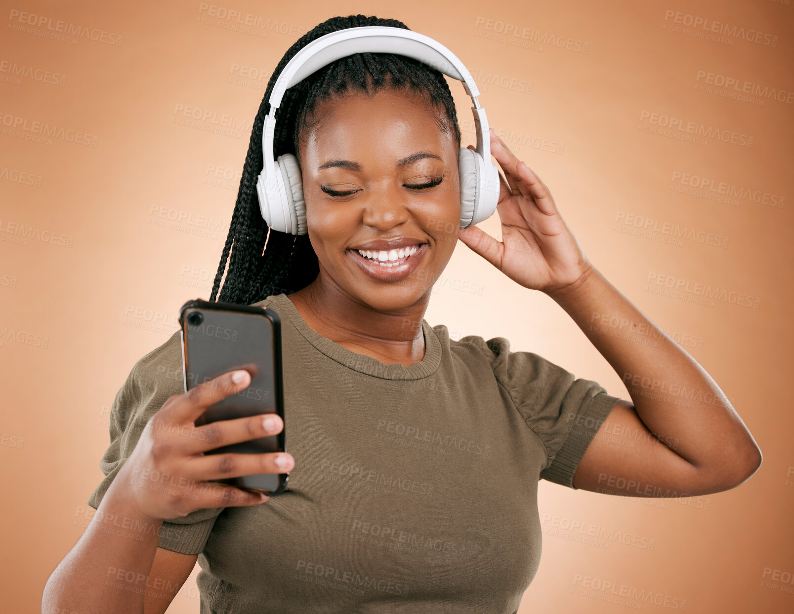 Buy stock photo Headphones, smartphone and black woman isolated on studio background for music streaming, dance and happy. Smile of african person, hand holding phone with audio technology for student subscription