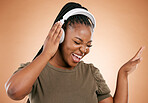 Headphones, singing and black woman isolated on studio background for mental health, energy and radio music. Singer, voice and gen z african person listening to audio technology with mockup space