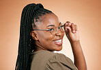 Black woman, smile and glasses for fashion, style or smart casual against a studio background. Portrait of happy African American female model face smiling for eyewear, spectacles and sight or vision