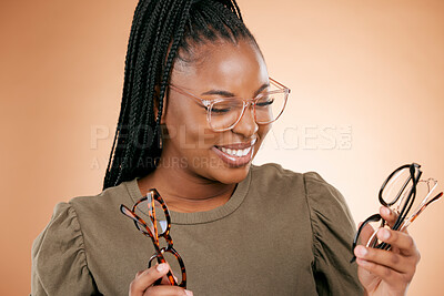 Buy stock photo Optometry, eyewear and woman with glasses in studio choosing a new frame for her prescription lens. Eye care, happy and African female with spectacles for optical health isolated by brown background.