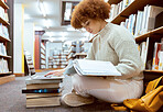 College learning, library and book reading with laptop of a black woman student on the ground. Education research, bookshelf and books of a young female looking studying for a school test or exam