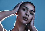 Face portrait, beauty skincare and woman in studio isolated on a blue background. Makeup light, cosmetics and aesthetics of female model satisfied after facial treatment for healthy and glowing skin.