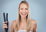 Hair straightener, face portrait and woman in studio isolated on a gray background. Beauty, haircare and laughing female model holding flat iron product for hairstyle, grooming and salon treatment.