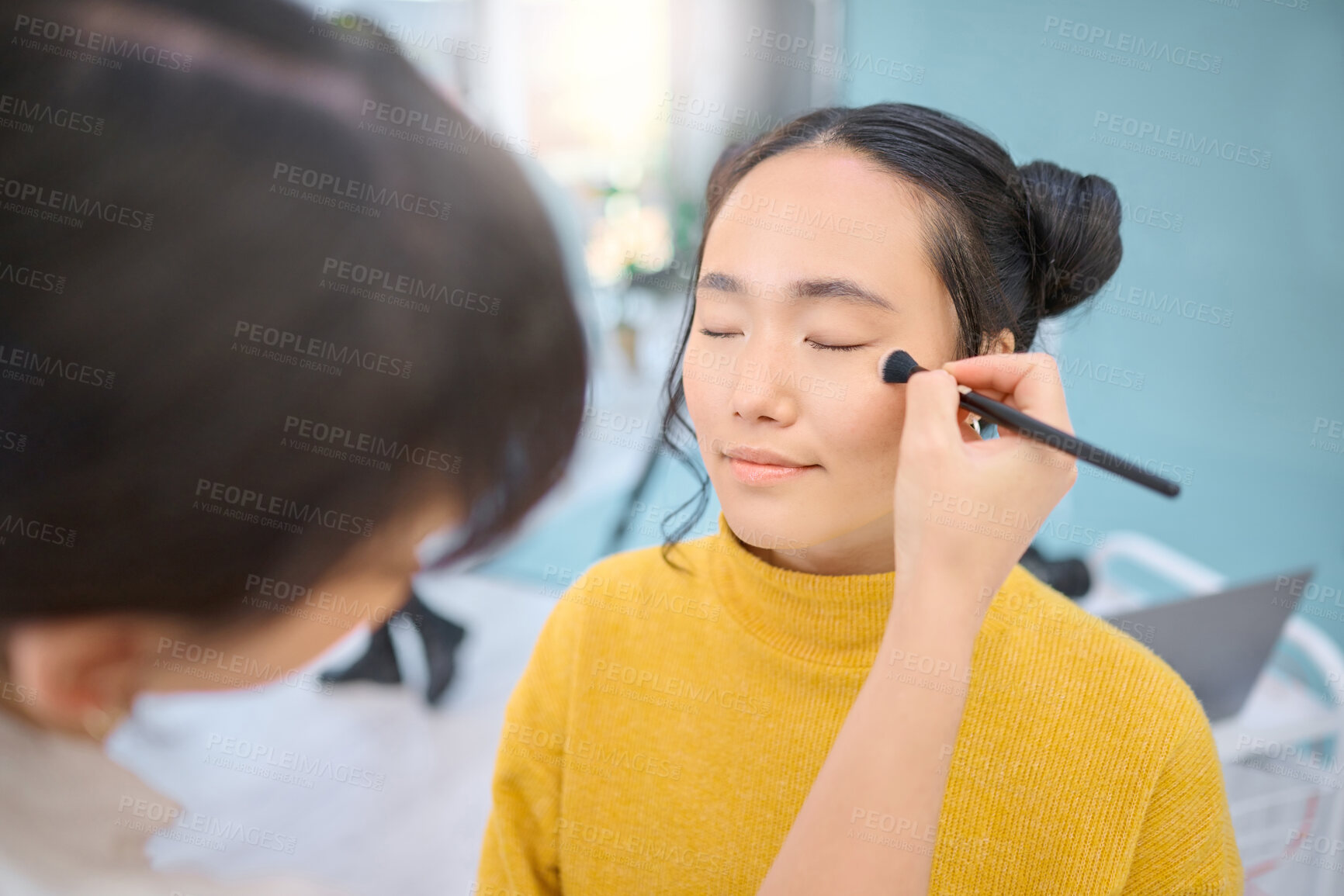 Buy stock photo Beauty, cosmetic and beautician doing makeup on a woman for a creative photoshoot in a studio. Cosmetics, art and stylist preparing a young Asian female model with a routine for a photography job.