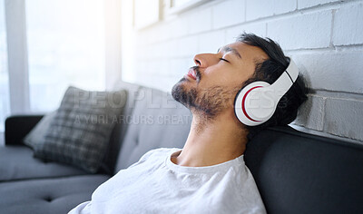 Buy stock photo Relax, music and man with headphones on sofa in home living room streaming radio or podcast. Meditation, technology and male on couch in lounge listening to peaceful song, audio or album in house.