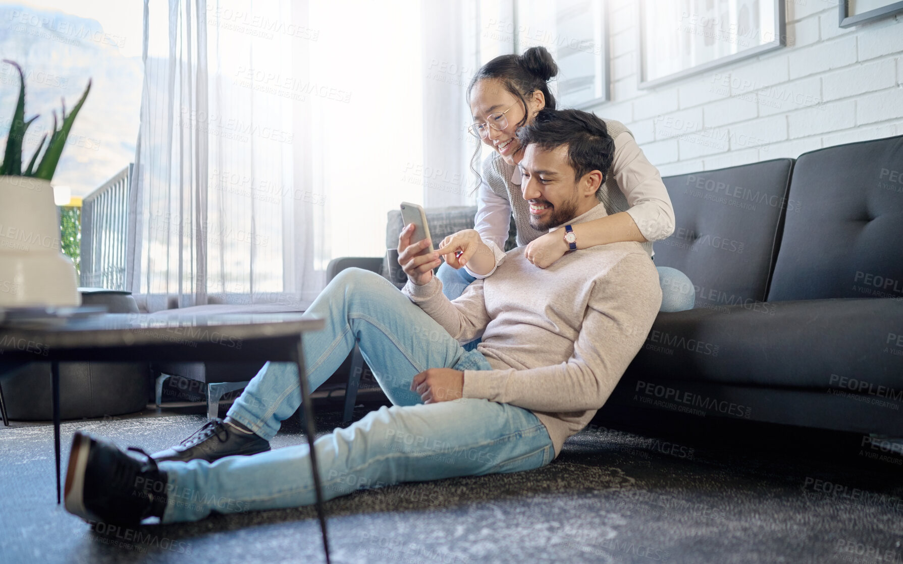 Buy stock photo Interracial, couple and people with phone on social media laughing at meme or funny internet content. Man, woman and lovers relax in home, house or apartment browsing the web, website or app