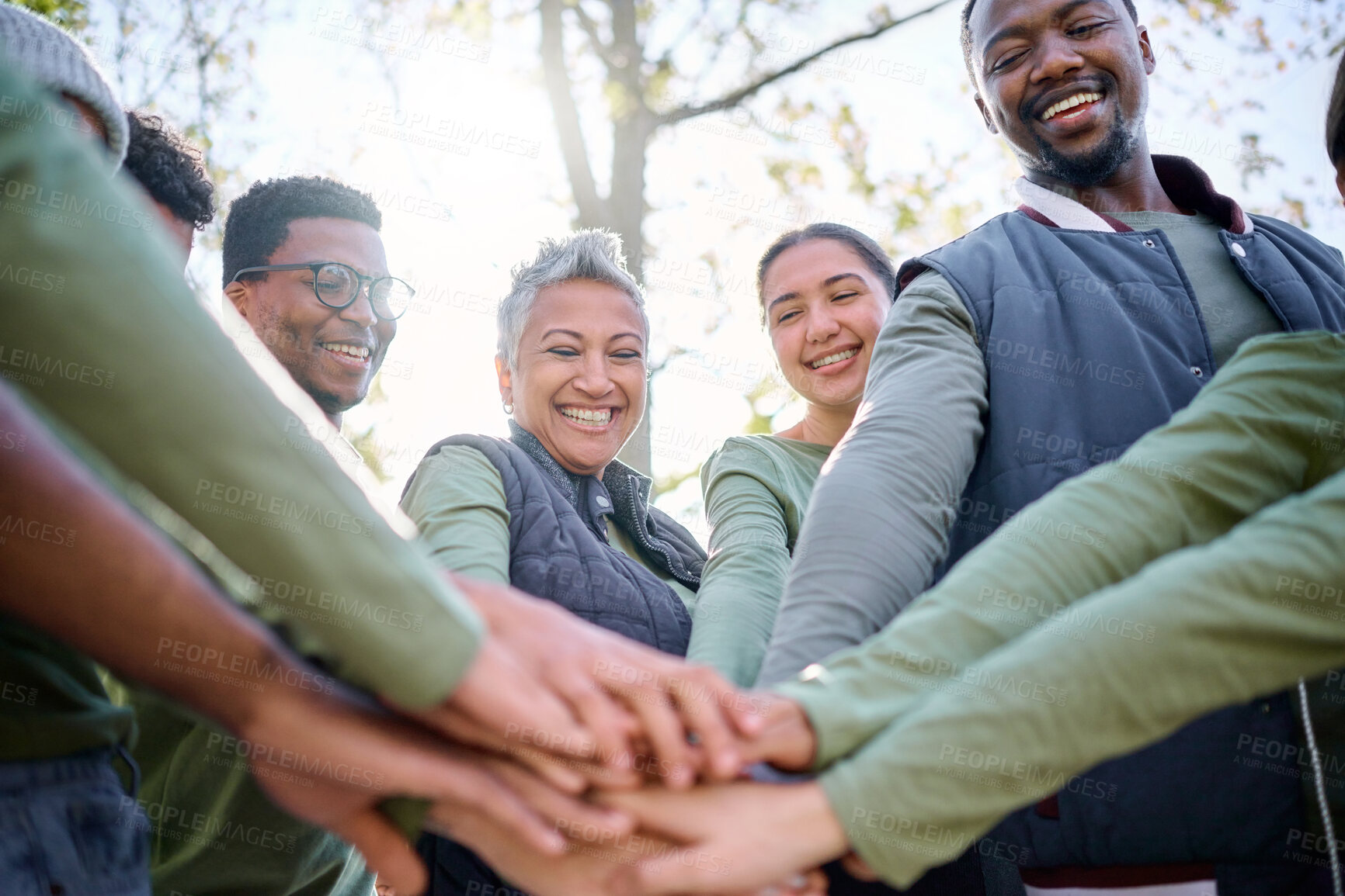 Buy stock photo Teamwork, motivation and huddle with senior friends hiking together in the forest or woods from below. Fitness, exercise or nature with a mature man and woman friend group putting hands in a circle