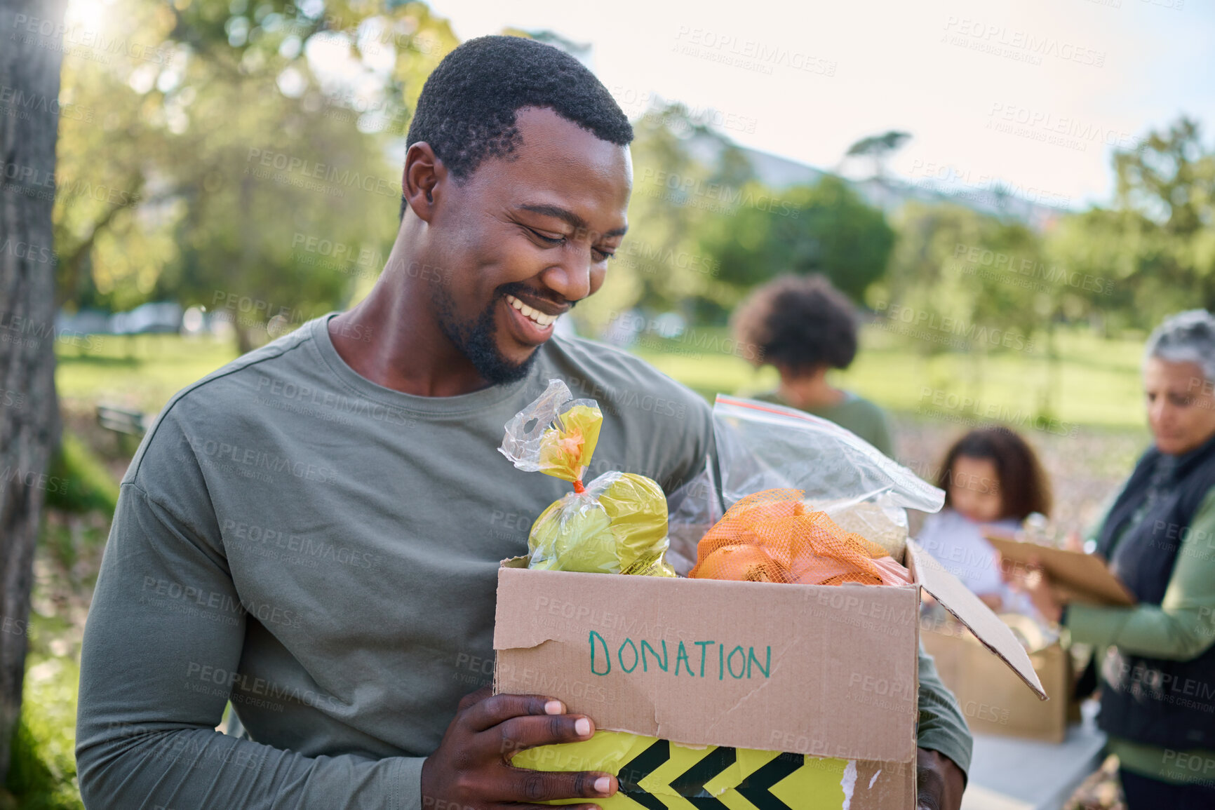 Buy stock photo Food, donation and man in park with smile and grocery box, happy, healthy diet at refugee feeding project. Fresh fruit, charity donations and help to feed people, support from farm volunteer at ngo.