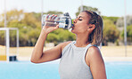 Water, thirsty and woman with a bottle after running, training hydration and energy on a court. Fitness, sports and athlete with a drink break after a workout, exercise and tired of sport in Germany