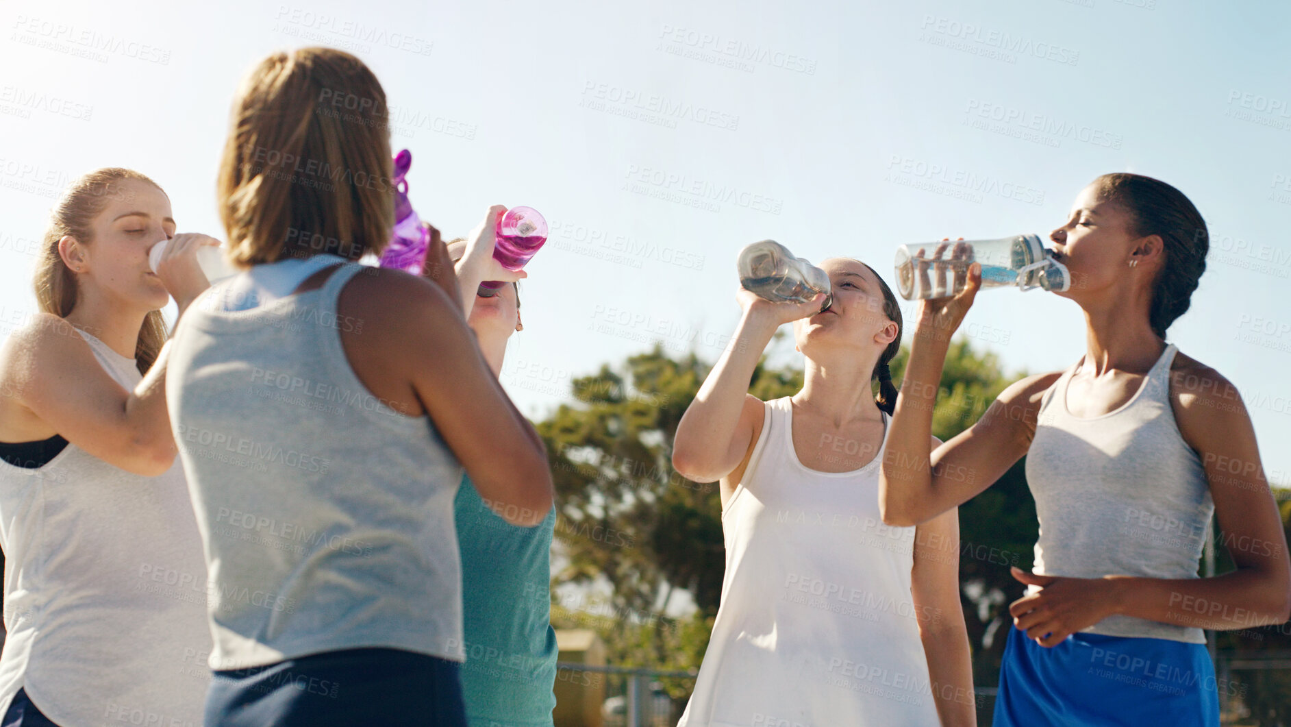 Buy stock photo Athletic woman, friends and drinking water for hydration during sports workout, training or practice together outside. Group of sporty women staying hydrated for healthy sport exercise in nature