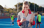 Hockey, trainer and texting by woman at a stadium for training, workout and fitness while browsing at match. Sports, coach and female happy, smile and excited for app, message and online text outside