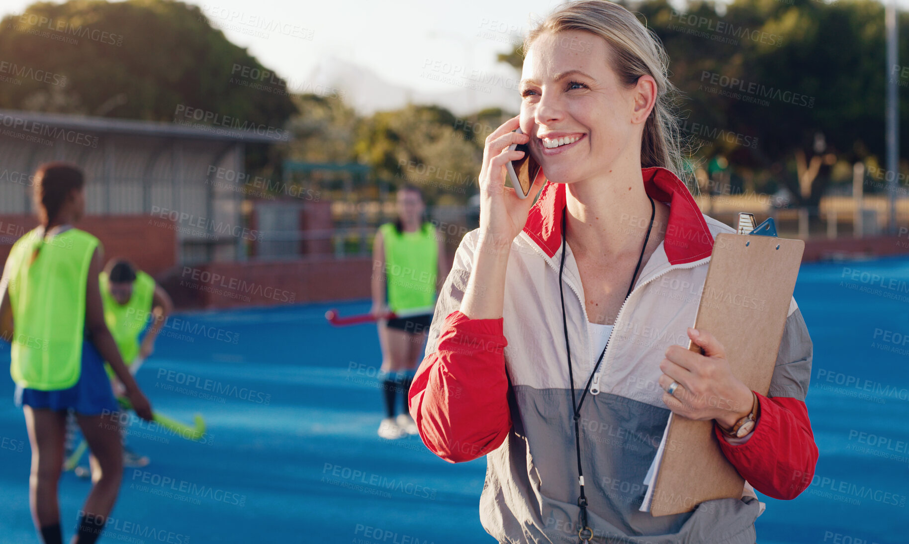 Buy stock photo Hockey, trainer and phone call by woman at a stadium for training, workout and fitness while talking during a match. Sports, coach and female happy, smile and excited while enjoying conversation 