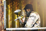 Paintball, war and camouflage with a sports man playing a military game for fun or training outdoor. Gun, soldier and target with a male athlete shooting a weapon outside during an army exercise