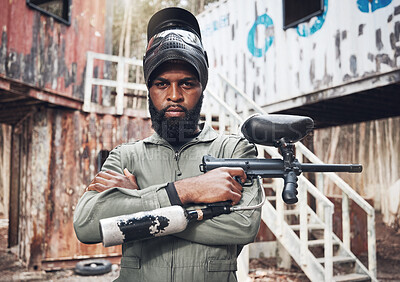 Buy stock photo Arms crossed, portrait and black man with a paintball gun for fitness, training or a game. Exercise, focus and serious African player with a rifle for action, military work and outdoor competition