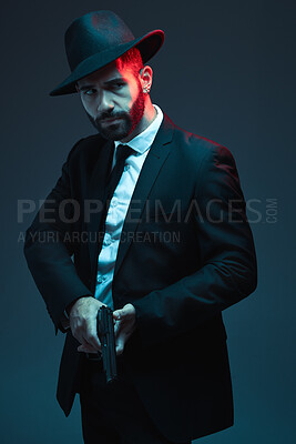 Buy stock photo Man, suit or holding gun on dark studio background in secret spy, isolated mafia leadership or crime lord security. Model, gangster or hitman with pistol in style, formal or fashion clothes aesthetic