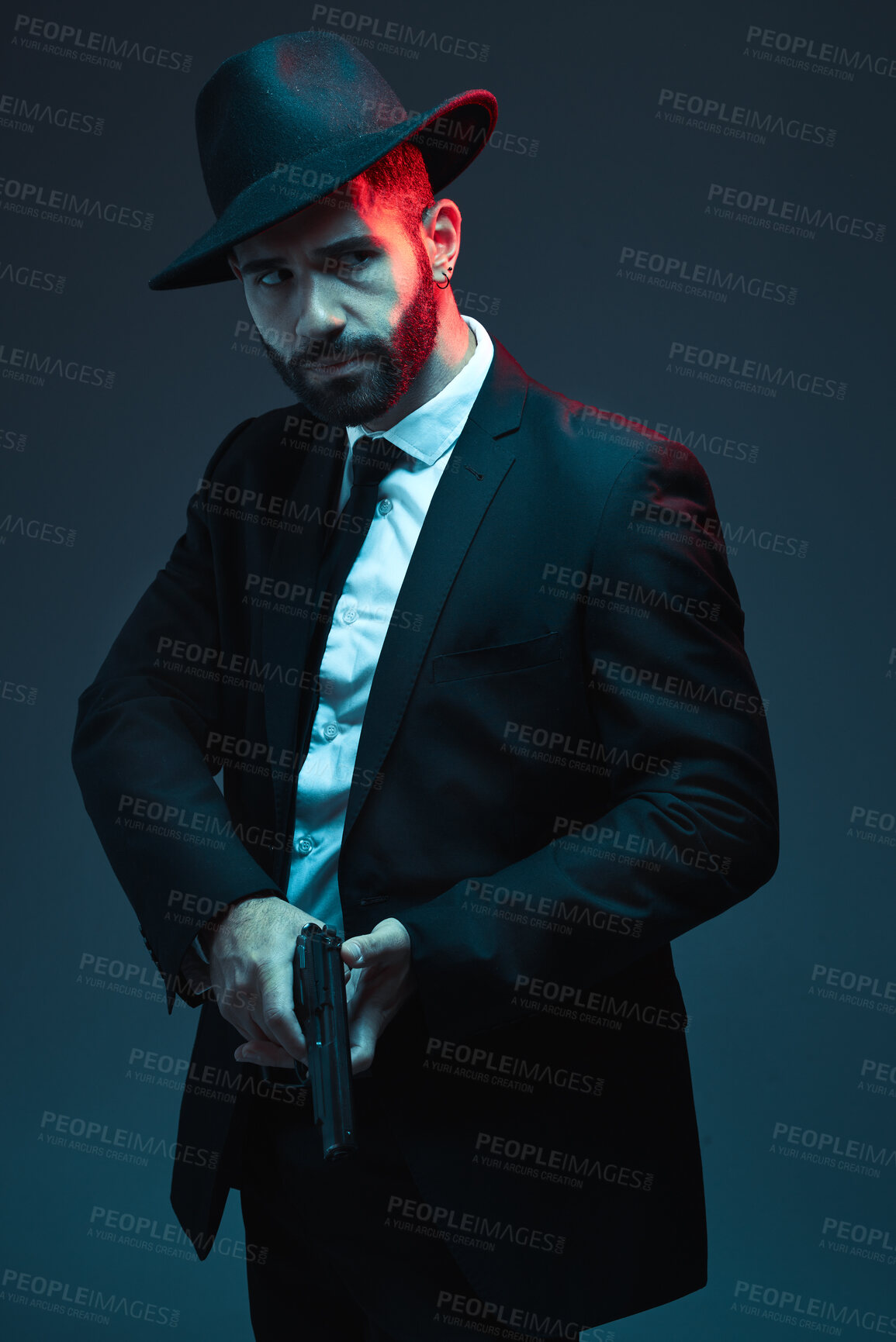 Buy stock photo Man, suit or holding gun on dark studio background in secret spy, isolated mafia leadership or crime lord security. Model, gangster or hitman with pistol in style, formal or fashion clothes aesthetic