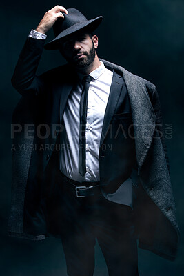 Buy stock photo Fashion, portrait and a man in a dark studio with confidence, clothes and a hat for vintage style. Model person in a suit and coat for winter, business or mystery as a spy on a black background