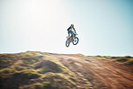 Motorbike, cycling and jump on blue sky mockup for speed challenge, sports and fearless athlete. Driver, air stunt and driving over hill with adrenaline, competition adventure and motorcycle power 