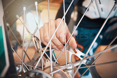 Buy stock photo Motorcycle, wheel and hands on spokes with a man at work in a repair shop or maintenance garage. Bike, mechanic and service with a professional handyman working on a bicycle rim in a workshop