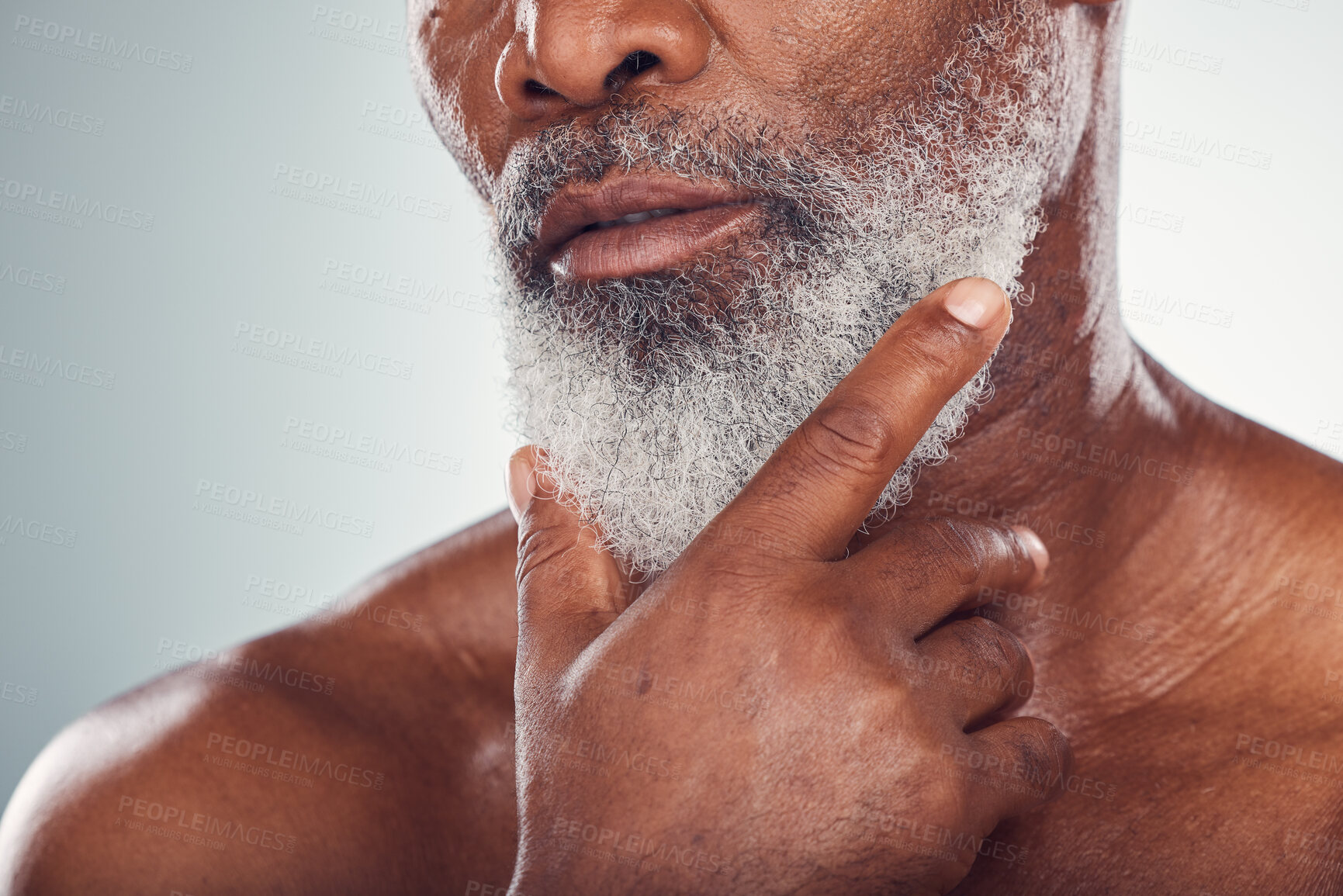 Buy stock photo Hand, beard and skin with a senior black man grooming in studio on a gray background for beauty or skincare. Face, hygiene and cosmetics with a mature male indoor to promote facial hair maintenance