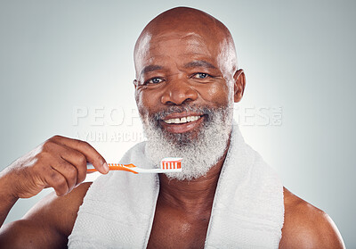 Black man brushing teeth, smile and toothbrush, mouth care and fresh breath, hygiene isolated on studio background. Health, wellness and cleaning with dental portrait, senior person and retirement