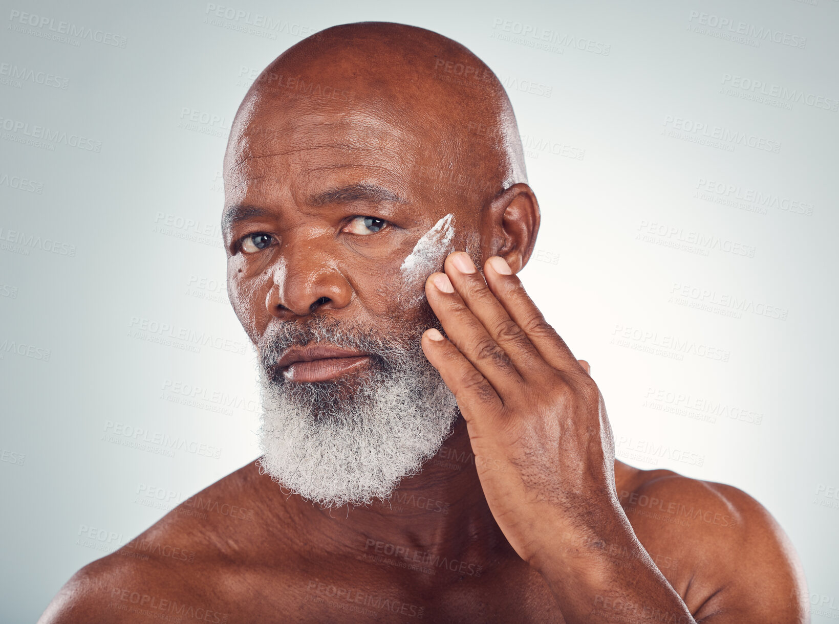 Buy stock photo Face cream, skincare and senior man in studio for wellness, beauty and grooming against grey background. Facial, skin and elderly model relax with luxury, cosmetics and wrinkle product while isolated